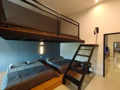 a bedroom with a bunk bed and a chair at Dawn de Ville-Private Pool BBQ Karaoke 34-40pax in Ipoh