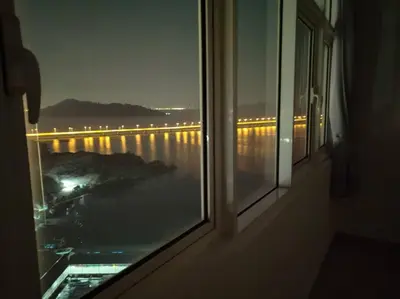a window with a view of a river and a bridge at Invincible Seaview Vacation Condo 3R3B 8Pax in Bayan Lepas