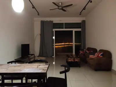 a living room with a table and a ceiling fan at Invincible Seaview Vacation Condo 3R3B 8Pax in Bayan Lepas