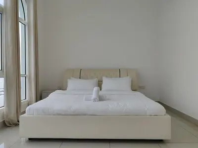 a white bed in a room with a large window at Invincible Seaview Vacation Condo 3R3B 8Pax in Bayan Lepas