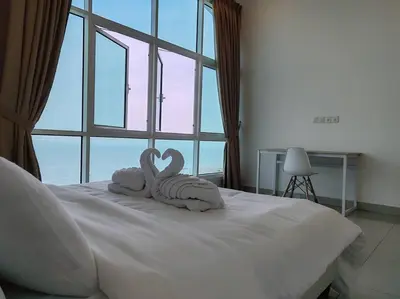 two swans towels sitting on top of a bed at Invincible Seaview Vacation Condo 3R3B 8Pax in Bayan Lepas