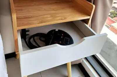 a drawer in a wooden cabinet with a controllers at Urban Muji Retreat Suites #3BR #2carparks in Jelutong