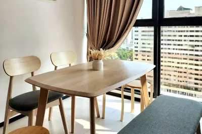 a wooden table and chairs in a room with a window at Urban Muji Retreat Suites #3BR #2carparks in Jelutong