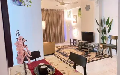 a living room with a dining table and a television at HOMESTAY ANGGUN SAFIYYA in Bayan Lepas