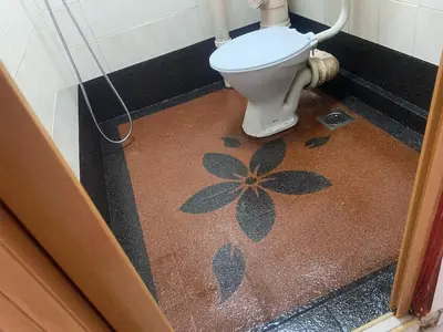 a bathroom with a toilet with a flower painted on the floor at HOMESTAY ANGGUN SAFIYYA in Bayan Lepas