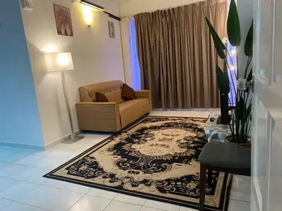 a living room with a chair and a rug at HOMESTAY ANGGUN SAFIYYA in Bayan Lepas