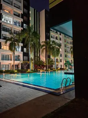 a large swimming pool with palm trees and buildings at 6-7Pax 3BR Waterpark Condo W Ps4 Near Ipoh Town in Kampong Pinji