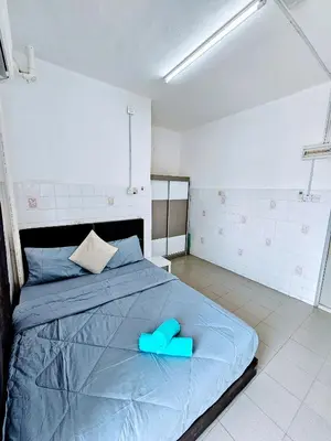 a bedroom with a bed with blue slippers on it at PANCHOR 6 HOSTEL in George Town