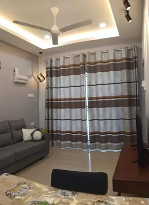 a living room with a couch and a curtain at Pantai Remis Homestay 118A in Pantai Remis