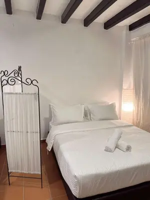 a bedroom with a large bed with white sheets at The Family Suit in George Town