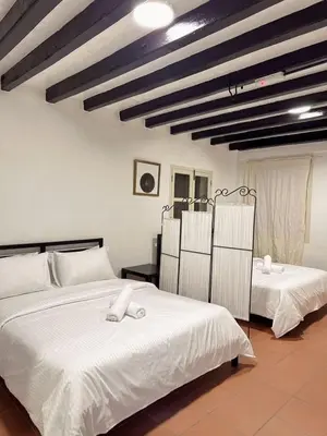 a bedroom with two beds with white sheets at The Family Suit in George Town