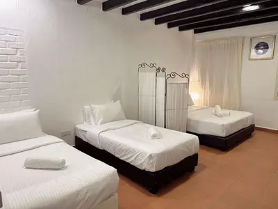 a bedroom with two beds with white sheets at The Family Suit in George Town