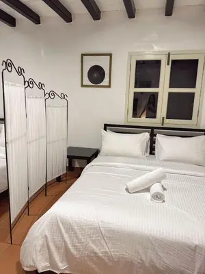 a bedroom with a large white bed with white pillows at The Family Suit in George Town