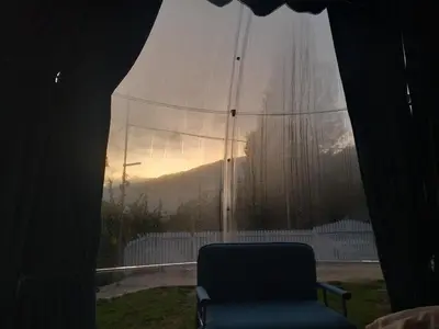 a chair sitting in front of a window with the sunset at The Starry Dome Family Room 2A 2K in Cameron Highlands