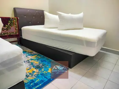 a bed with white sheets and pillows in a room at HAZZ Homestay Kulim in Kulim