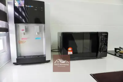 a microwave sitting on a counter next to a refrigerator at HAZZ Homestay Kulim in Kulim
