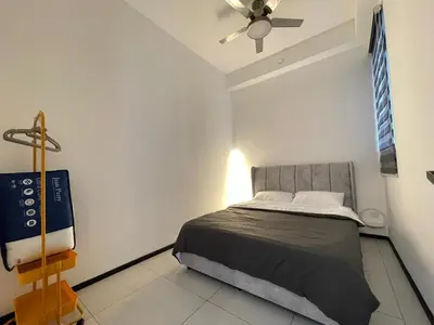a bedroom with a bed and a ceiling fan at Urban Suites - Dolphin's Home in Jelutong