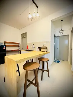 a kitchen with a wooden counter and two stools at Jc Homestay in Ipoh