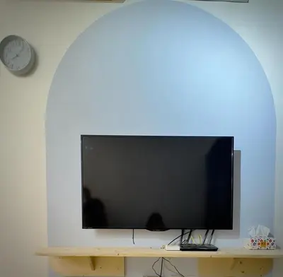 a flat screen tv sitting on a table with a clock at Jc Homestay in Ipoh