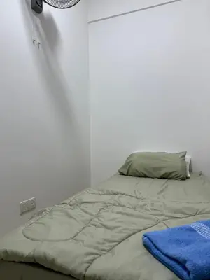 a bed in a white room with a blanket on it at Jc Homestay in Ipoh
