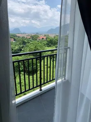 a room with a balcony with a view of trees at Modern Lux Suite, The Cove Hillside Residence in Ipoh
