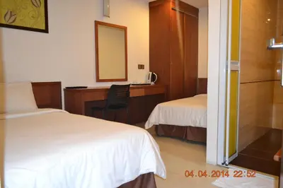 a hotel room with two beds and a mirror at AG Hotel Penang in George Town