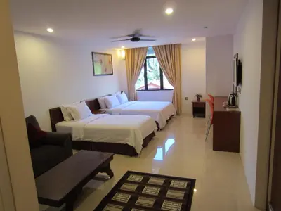 a hotel room with two beds and a couch at AG Hotel Penang in George Town