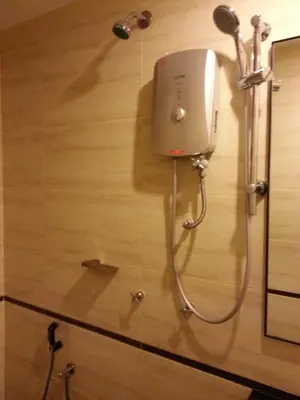 a shower in a bathroom with a blow dryer on a wall at AG Hotel Penang in George Town