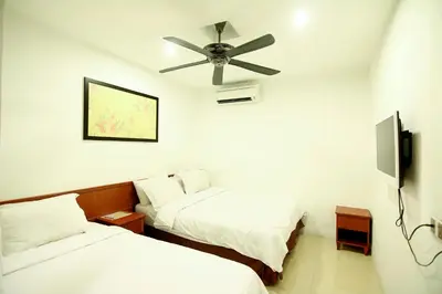 a room with two beds and a ceiling fan at AG Hotel Penang in George Town
