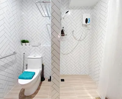 a white bathroom with a toilet with a blue seat at 35 BeachHouse Batu Ferringhi 7 Bedroom 7 Bathroom EV friendly in Batu Ferringhi