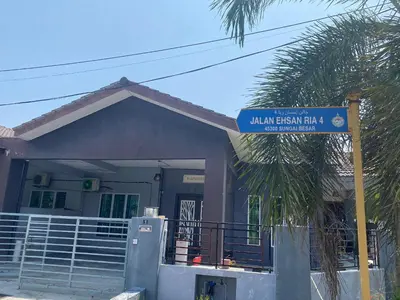 a house with a blue street sign in front of it at Humayyah Homestay in Sungai Besar