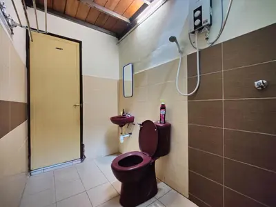 a bathroom with a pink toilet and a sink at Humayyah Homestay in Sungai Besar