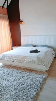 a bedroom with a bed with a white headboard and a rug at Silverpart Resort Fraser Hill C3-6-2 Forest View High Floor No lift in Bukit Fraser