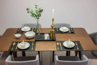 a dining room table with two chairs and plates and a vase at Serene Modern Family Retreat(2-7 pax)&Sunrise View in Cameron Highlands