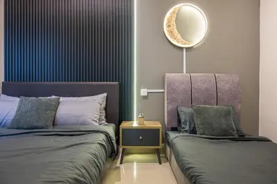 a bedroom with two beds and a mirror on the wall at Serene Modern Family Retreat(2-7 pax)&Sunrise View in Cameron Highlands