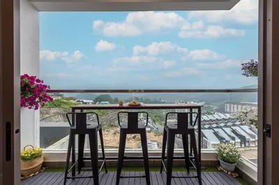 a balcony with a table and chairs and a view at Serene Modern Family Retreat(2-7 pax)&Sunrise View in Cameron Highlands