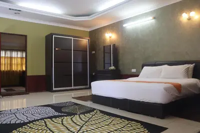 a bedroom with a large bed and a large window at Bunga Raya Resort Parit Buntar in Parit Buntar
