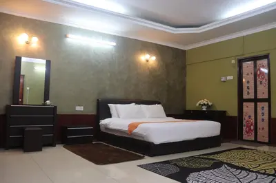 a bedroom with a large bed and a mirror at Bunga Raya Resort Parit Buntar in Parit Buntar