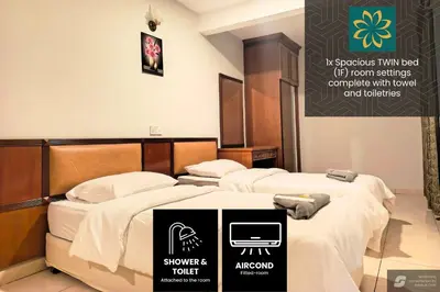 two beds in a hotel room with avertisement for at Thara Beach Resort in Pasir Bogak
