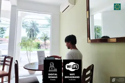a man sitting at a table with a box at Thara Beach Resort in Pasir Bogak