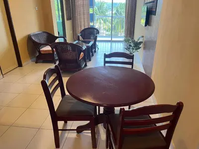 a wooden table and chairs in a room at Thara Beach Resort in Pasir Bogak
