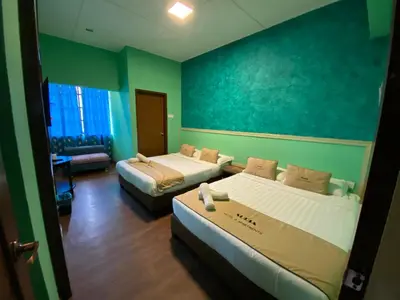 two beds in a room with green walls at Suria Cameron Hotel in Tanah Rata