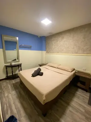 a bedroom with a bed with a black object on it at Suria Cameron Hotel in Tanah Rata