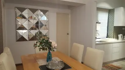a dining room table with a vase of flowers on it at Batu Ferringhi Seaview Apartment in Batu Ferringhi