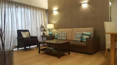 a living room with a couch and a table at Batu Ferringhi Seaview Apartment in Batu Ferringhi