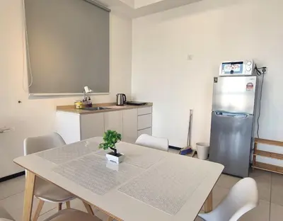 a kitchen with a table with chairs and a refrigerator at Cityscape Suite, 4 to 5 Pax at Urban Suites Georgetown by SuperStay in Jelutong