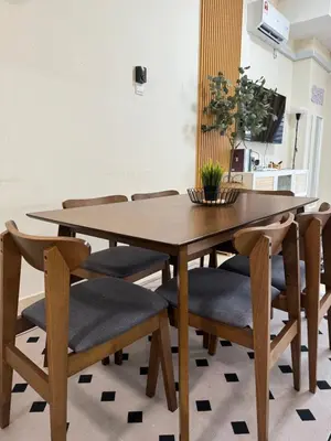 a dining room table and chairs with a wooden table at Orked Homestay Bagan Serai in Bagan Serai