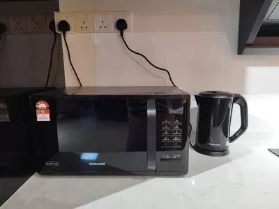 a microwave sitting on top of a kitchen counter at Cozy Homestay \u6e29\u99a8\u6c11\u5bbf @The Horizon Ipoh\u516c\u5bd3\u65e0\u8fb9\u6cf3\u6c60 (6-10\u4eba\uff09 in Ipoh