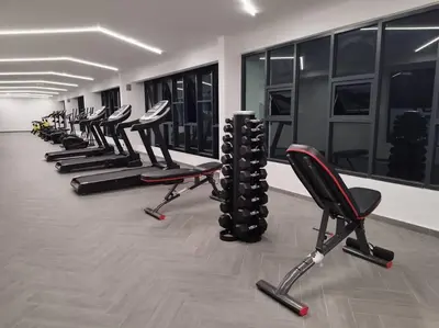a row of exercise chairs in a gym with windows at Cozy Homestay \u6e29\u99a8\u6c11\u5bbf @The Horizon Ipoh\u516c\u5bd3\u65e0\u8fb9\u6cf3\u6c60 (6-10\u4eba\uff09 in Ipoh