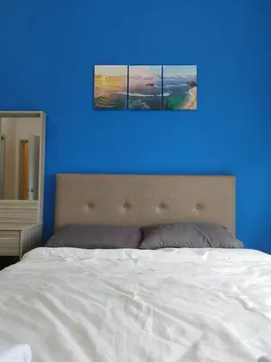 a blue room with a bed and a blue wall at Cozy Homestay \u6e29\u99a8\u6c11\u5bbf @The Horizon Ipoh\u516c\u5bd3\u65e0\u8fb9\u6cf3\u6c60 (6-10\u4eba\uff09 in Ipoh